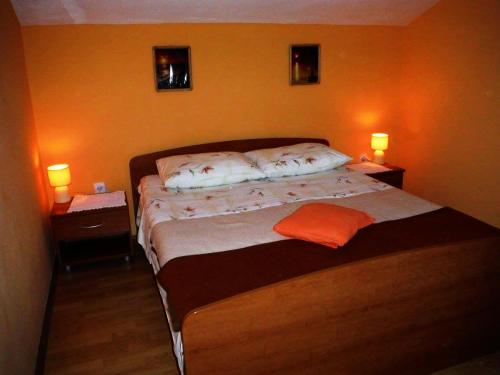 een slaapkamer met een bed met twee lampjes aan de muur bij Apartment Bogadi in Prvić Luka