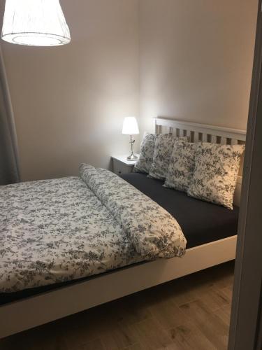 1 dormitorio con 1 cama y 1 lámpara en una mesa en Apartamenty AMALIA, en Rewal