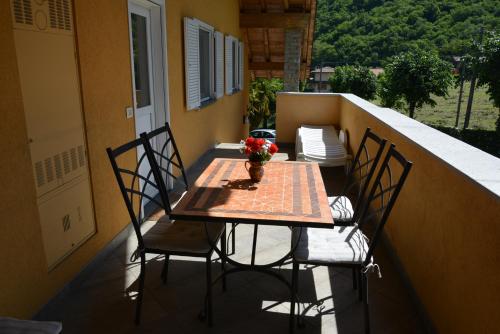 a table and chairs on a balcony with a table and flowers at Casa Bellavista 1 in Colico
