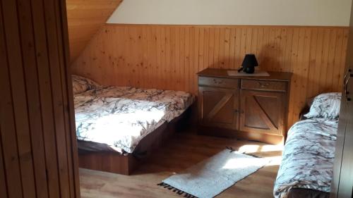 a bedroom with a bed and a dresser with a lamp at Chalupa JANINA in Terchová