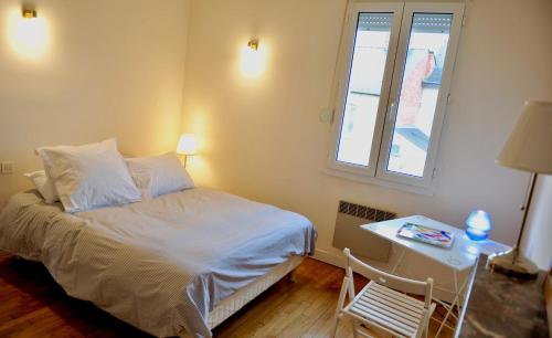 a bedroom with a bed and a table and a window at Papyrus Saint-Pierre in Mordelles