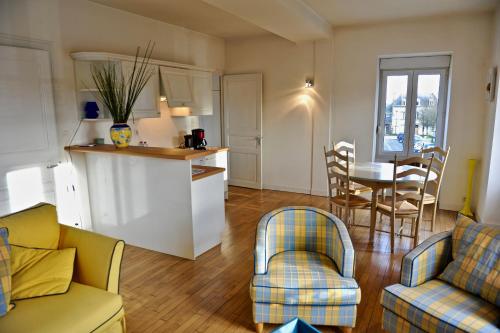 ein Wohnzimmer mit Küche und Tisch und Stühlen in der Unterkunft Papyrus Saint-Pierre in Mordelles