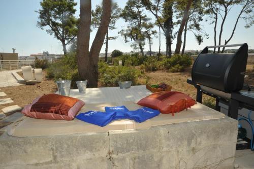 a table with two pillows on top of a grill at MARIMAR - Apartments OTRANTO in Otranto
