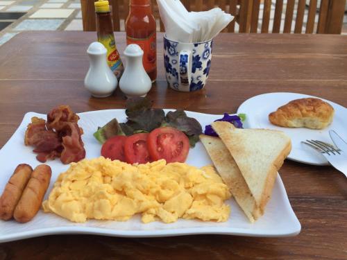 a plate of breakfast food on a wooden table at BC Summer Beach in Pran Buri