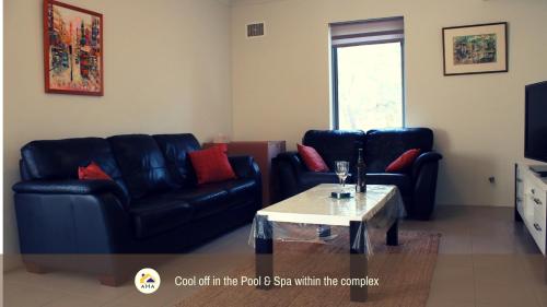 a living room with two leather couches and a coffee table at SERENITY of MANDURAH STRA6210P5QC05G7 in Mandurah