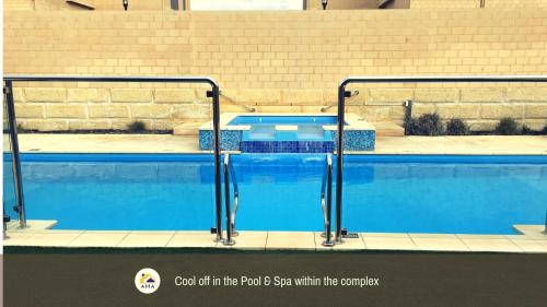 a swimming pool with blue water in a building at SERENITY of MANDURAH in Mandurah