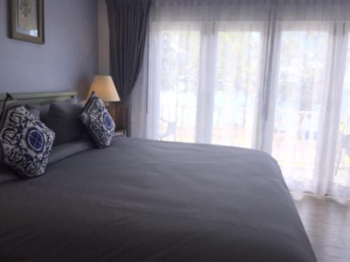 a bedroom with a large bed with a large window at BC Summer Beach in Pran Buri