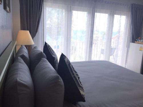 a bedroom with a large bed with a large window at BC Summer Beach in Pran Buri