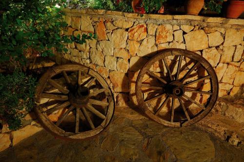 two wooden wagon wheels leaning against a stone wall at Lycia Hotel in Kas