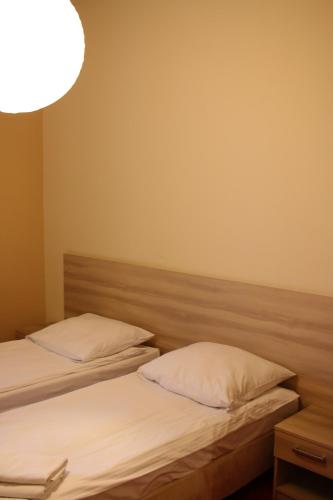 two beds with white pillows in a room at Amicus Żoliborz in Warsaw