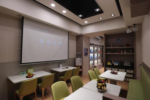 a classroom with tables and chairs and a projection screen at Yue Guang Homestay in Jian