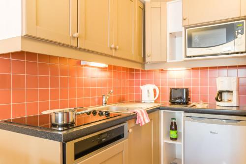 a kitchen with a sink and a stove top oven at Résidence Pierre & Vacances Le Tikal in Val Thorens