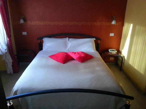 a bed with two red pillows on top of it at Park Hotel in Chieri