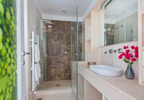 a bathroom with a shower, sink, and tub at Capri Wine Hotel in Capri