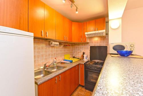 a kitchen with wooden cabinets and a sink at Apartment Josip 1562 in Pula