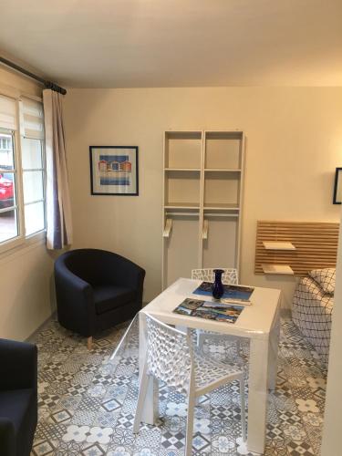 - un salon avec une table blanche et une chaise dans l'établissement A l'Ancre Bleue, au Tréport