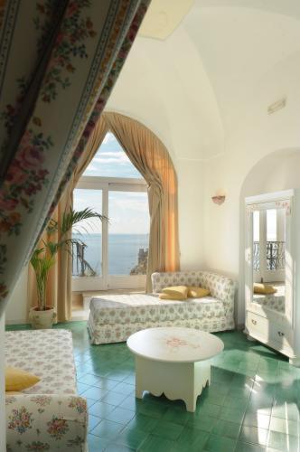 a living room with a couch and a table at Villa Rosa in Positano