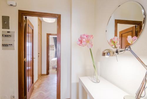 マドリードにあるCómodo apartamento Plaza Mayor-Palacio Realのバスルーム(鏡、花瓶のピンクの花付)