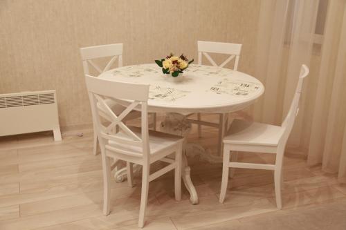 a white table and chairs with a dog laying under it at WINE & ROSE BOUTIQUE HOTEL in Kharkiv