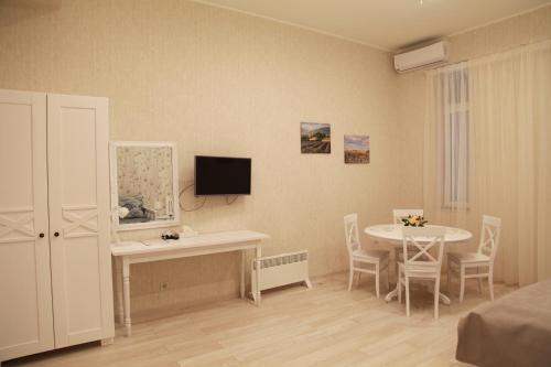 a living room with a table and a dining room at WINE & ROSE BOUTIQUE HOTEL in Kharkiv