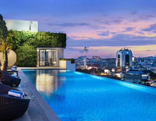 a swimming pool on top of a building with a city skyline at Mercure Bandung City Centre in Bandung