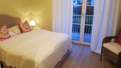 a bedroom with a white bed and a window at The Little Guesthouse in Salzburg