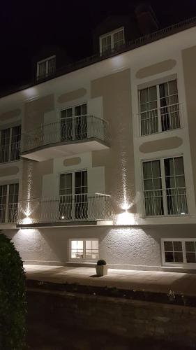 a large white building with a balcony at night at The Little Guesthouse in Salzburg