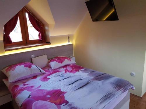 a bedroom with a large bed with pillows and a window at TULPIKA 13 in Moravske-Toplice