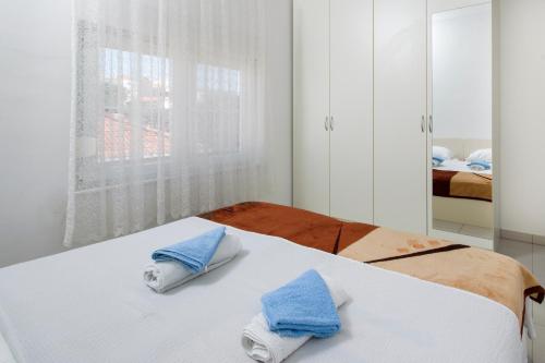 a bedroom with a bed with blue towels on it at Panorama lux apartment in Rogoznica