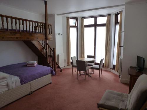 ロンドンにあるBelsize Park Apartmentsのベッドルーム1室(ベッド1台、テーブル、椅子付)
