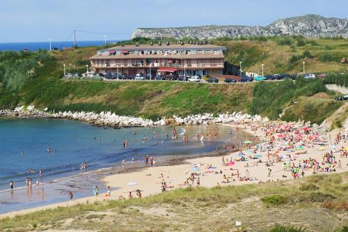 Grupa ludzi na plaży w pobliżu oceanu w obiekcie apartamento abuhardillado w mieście Cuchia