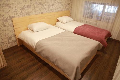 two twin beds in a room with wood floors at WINE & ROSE BOUTIQUE HOTEL in Kharkiv