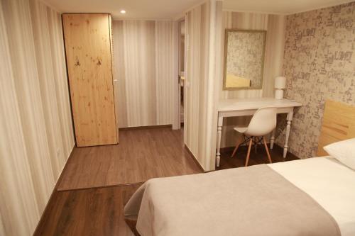 a hotel room with a bed and a desk at WINE & ROSE BOUTIQUE HOTEL in Kharkiv