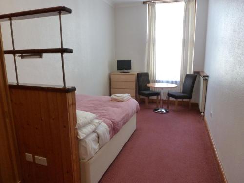 ロンドンにあるBelsize Park Apartmentsのベッドルーム1室(ベッド1台、デスク、テーブル付)