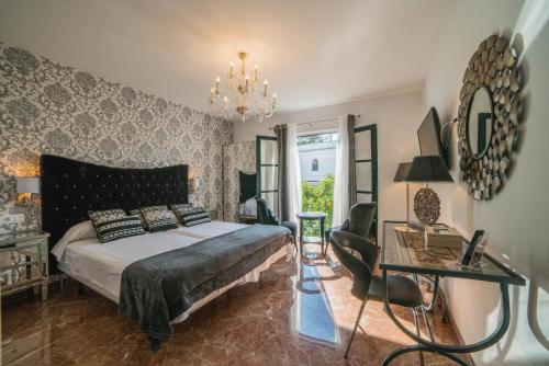 a bedroom with a bed and a table and a mirror at Rey Don Pedro Luxury Home in Seville