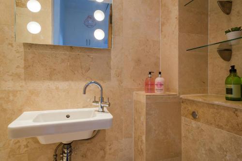 a bathroom with a sink and a mirror at Historic Edinburgh 1890s Home Turned Relaxing Retreat in Edinburgh