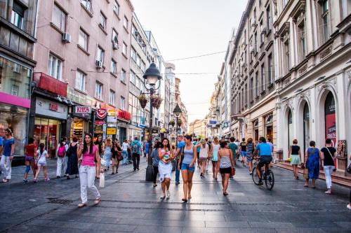 Un gruppo di persone che camminano lungo una strada trafficata della città di City Code In Joy a Belgrado
