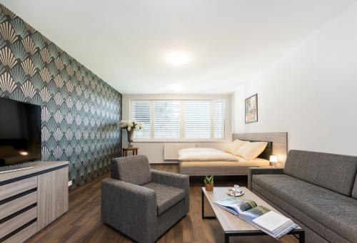 un soggiorno con un divano e una TV di Barok Hotel and Apartments a Bratislava