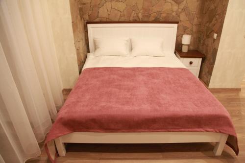 a bed with a red blanket on top of it at WINE & ROSE BOUTIQUE HOTEL in Kharkiv