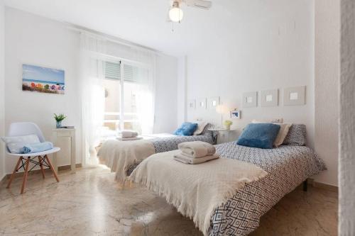 ロケタス・デ・マルにあるApartamento Cincaのベッドルーム1室(青い枕付きのベッド3台付)