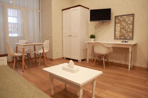 a living room with a couch and a table and a desk at WINE & ROSE BOUTIQUE HOTEL in Kharkiv