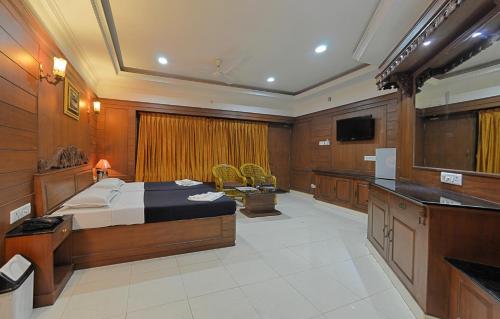 a bedroom with a bed and a television in it at Hotel Mahabs in Mahabalipuram