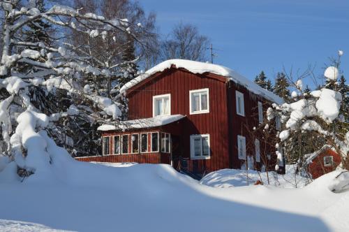 a red house in the snow with snow covered trees at MUSES BNB Bed & Breakfast in Bergvik