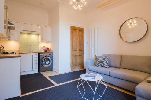 a living room with a couch and a table at Historic Edinburgh 1890s Home Turned Relaxing Retreat in Edinburgh