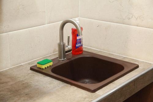 a kitchen sink with a faucet and a sponge at WINE & ROSE BOUTIQUE HOTEL in Kharkiv