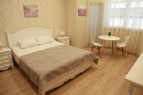 a bedroom with a bed and a table and chairs at WINE & ROSE BOUTIQUE HOTEL in Kharkiv
