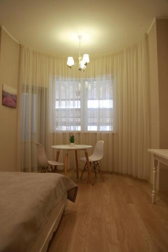 a bedroom with a bed and a table and a window at WINE & ROSE BOUTIQUE HOTEL in Kharkiv