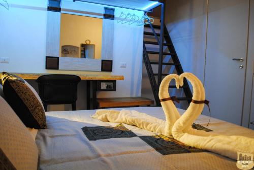 a bedroom with a bed with a towel forming a heart at The Bridge Suites in Gravina in Puglia