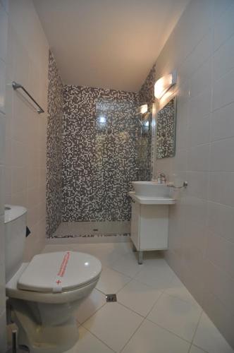 a bathroom with a toilet and a sink and a shower at Guest House ASK in Primorsko