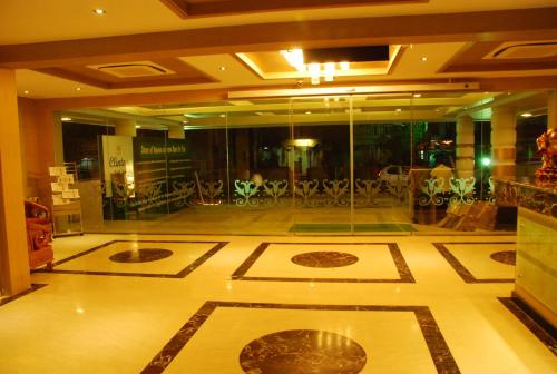 a lobby with a room with tables and chairs at Clinton Park Inn in Velānganni